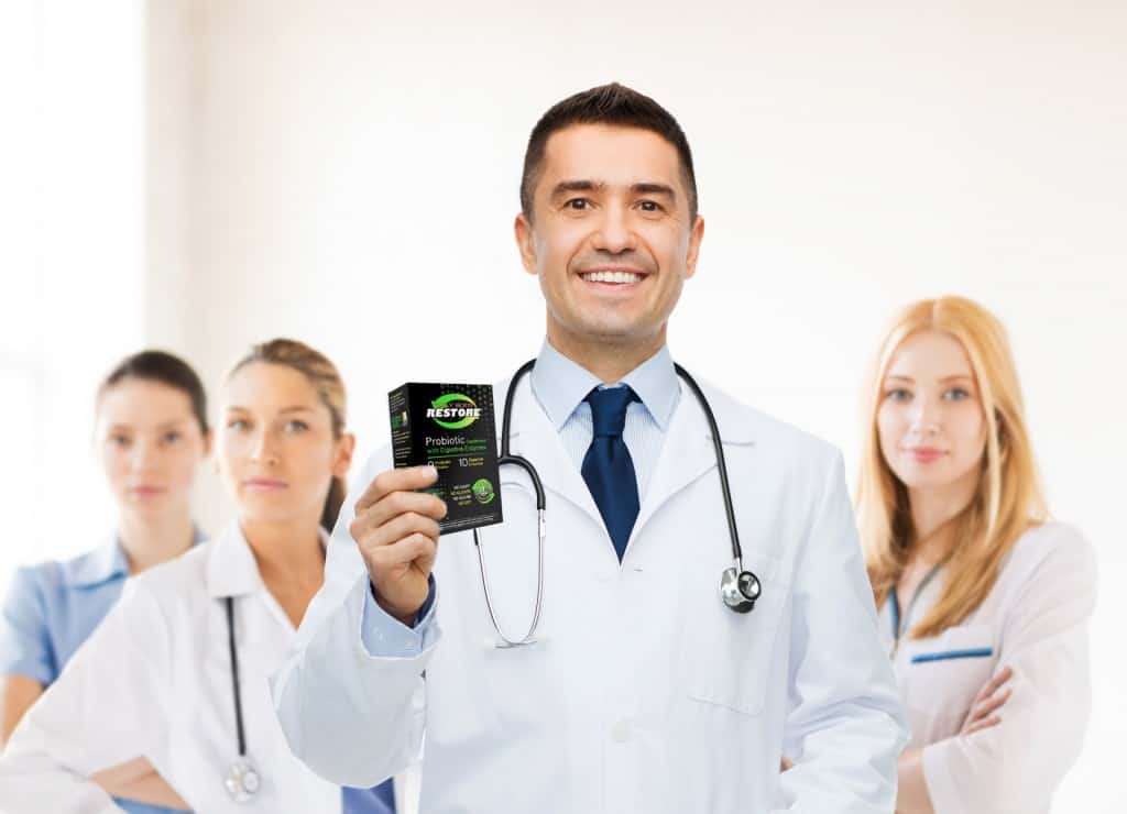 Daily Body Restore Probiotics Supplement - smiling male doctor in white coat with tablets over group of medics at hospital background